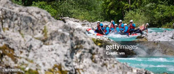 people adjusting balance in raft during riding in rocky section of track - whitewater rafting stock pictures, royalty-free photos & images