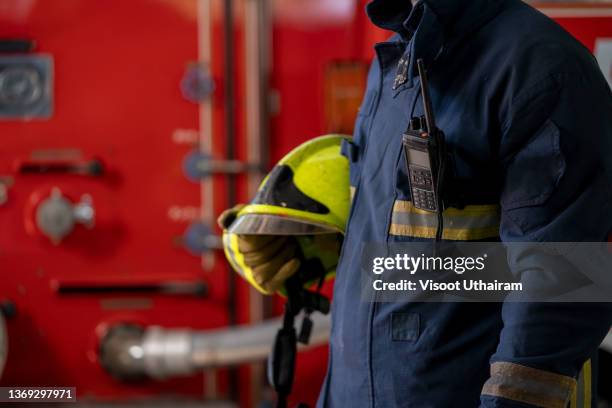 fireman wearing uniform and helmet at fire station. - patriot day stock pictures, royalty-free photos & images