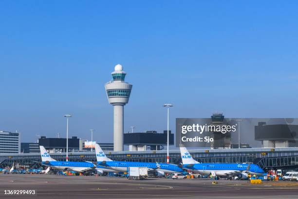 airplanes at amsterdam schiphol airport in holland - vliegveld stockfoto's en -beelden