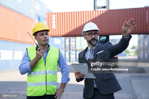 dock worker walking inspection the shipping container at the storage container yard - vorarbeiter stock-fotos und bilder