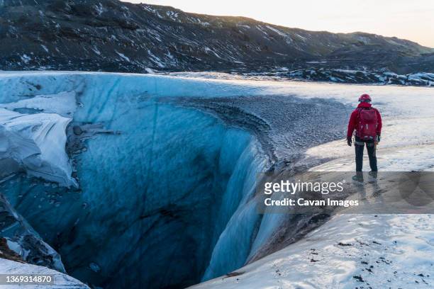 guide exploring sink hole on glacier in iceland - myrdalsjokull glacier stock pictures, royalty-free photos & images