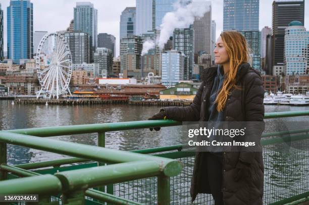 female looking at seattle downtown from ferry boat - commuter ferry stock pictures, royalty-free photos & images