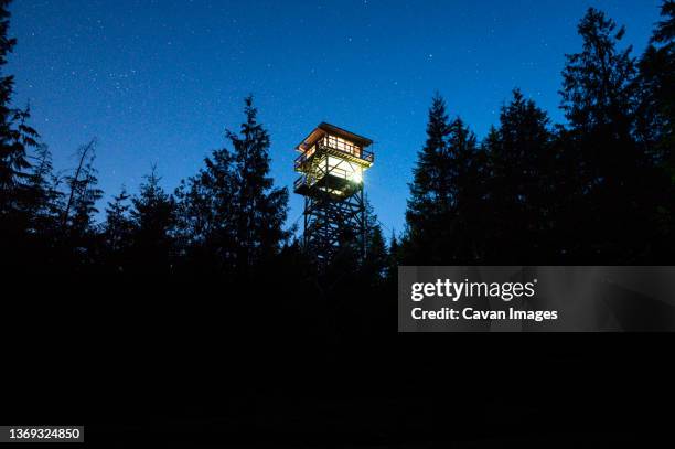 heybrook fire lookout tower glowing at night - wachturm stock-fotos und bilder