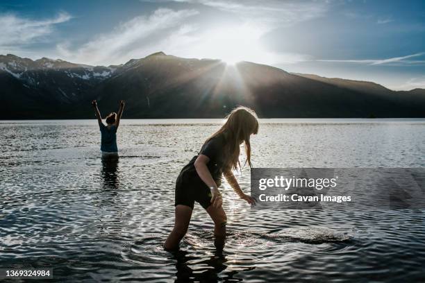 sisters splashing and playing in alpine lake - white moose stock pictures, royalty-free photos & images