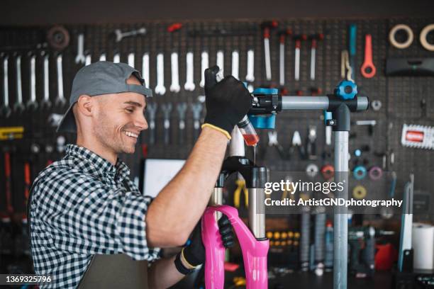 lubricating a suspension fork in bike repair shop - bike mechanic stockfoto's en -beelden