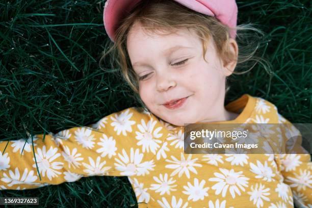 girl with red hair lying on grass - loose stock pictures, royalty-free photos & images