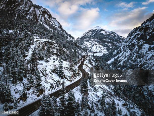 snowy road snakes through mountains, red mountain pass, colorado - ouray colorado stock pictures, royalty-free photos & images