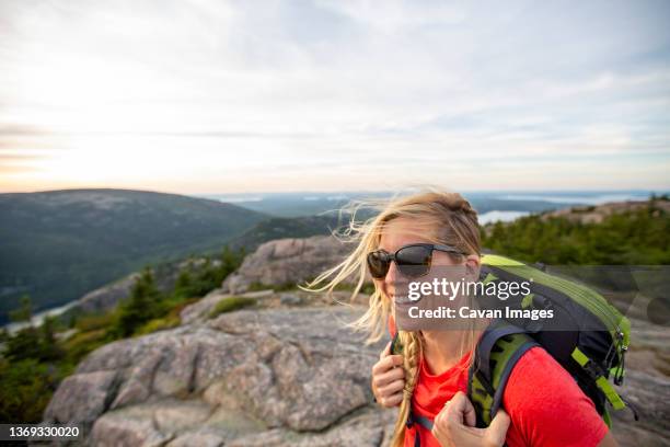 smiling mid adult woman hikes in acadia national park, maine - acadia national park stock pictures, royalty-free photos & images