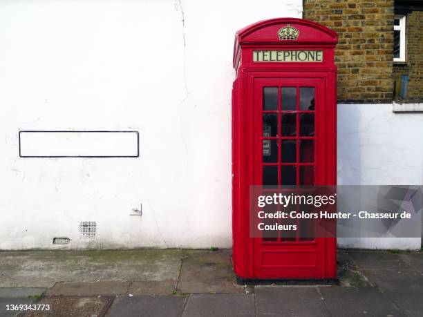 red english telephone booth and empty wall and sidewalk in london - telefonzelle stock-fotos und bilder