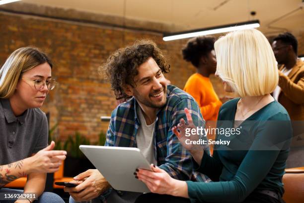 three young colleagues sitting and analyzing paperwork. start-up business. - open discussion stock pictures, royalty-free photos & images