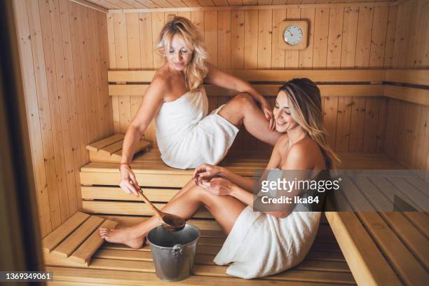 hermosas mujeres en una sauna en el centro de bienestar - mother daughter towel fotografías e imágenes de stock