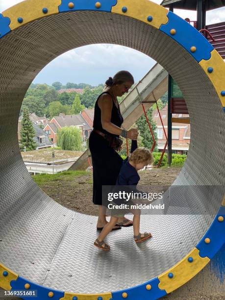 toddler boy with his grandmother in the carousel - nanny stock pictures, royalty-free photos & images