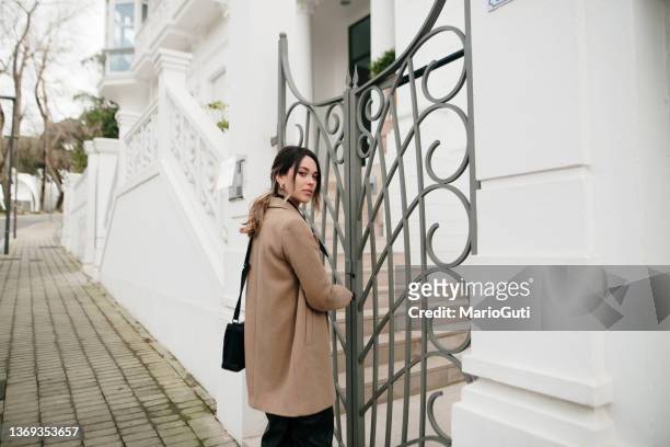 young woman opening a apartment gate - house fence stock pictures, royalty-free photos & images