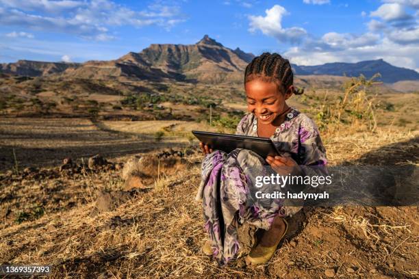 little african girl is using digital tablet, east africa - third world stock pictures, royalty-free photos & images