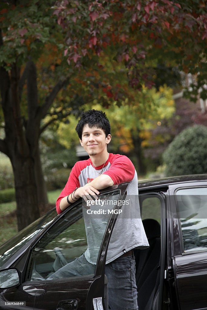 Young man poses with car