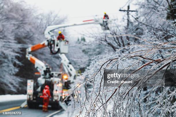 wiederherstellung der stromversorgung während des eissturms - extremwetter stock-fotos und bilder