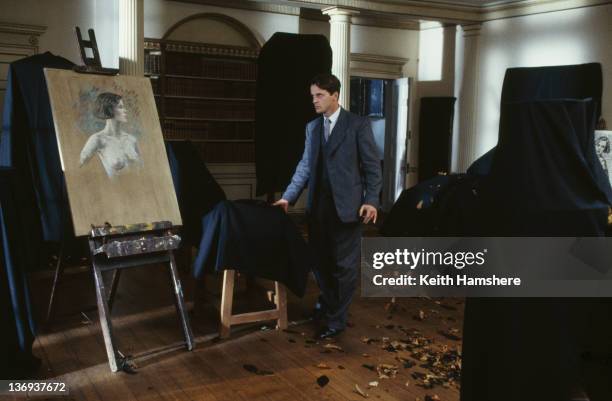 American actor Aidan Quinn uncovers a painting in a scene from the film 'Haunted', 1995.