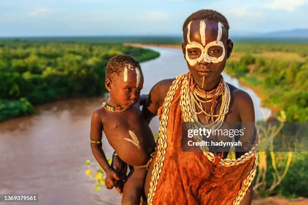 woman from karo tribe holding her baby, ethiopia, africa - african tribal face painting 個照片及圖片檔