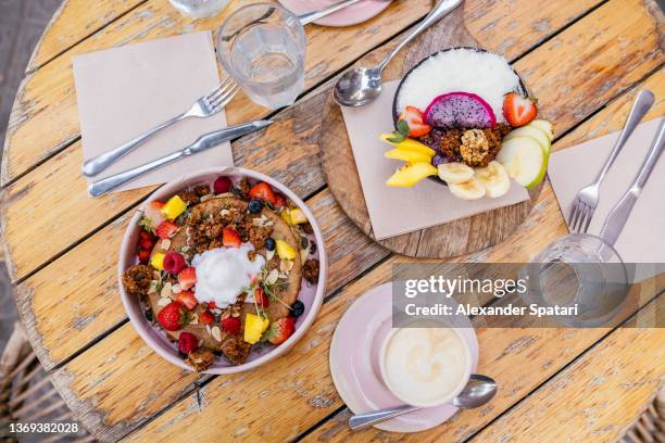 healthy vegan breakfast at the cafe, high angle view - mango coconut stock-fotos und bilder