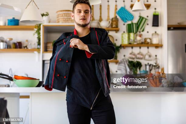 junger männlicher koch zieht sich an, bereitet sich auf das kochen vor - get dressed male stock-fotos und bilder