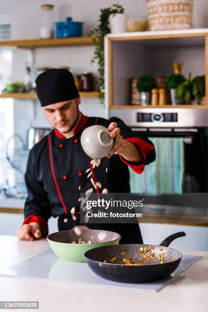 chef profesional vertiendo champiñones picados en una sartén - mirepoix comida fotografías e imágenes de stock