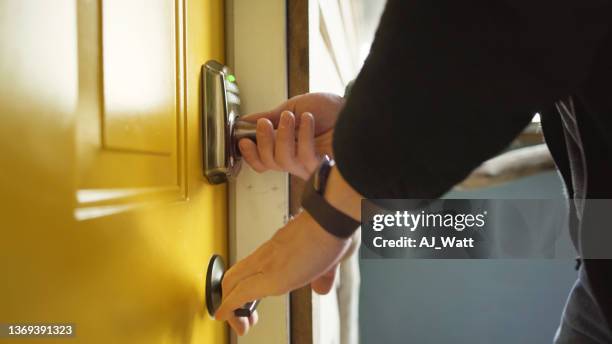 man entering his holiday rental after entering a pin code on a keypad - man opening door stock pictures, royalty-free photos & images