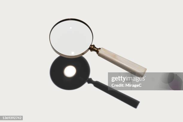 magnifying glass focus sunlight into a spot - vergrootglas stockfoto's en -beelden