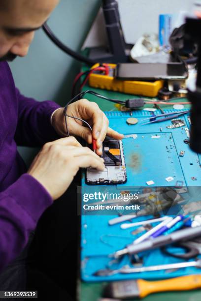 technician disassembling smartphone with screwdriver. - dismantling stock pictures, royalty-free photos & images
