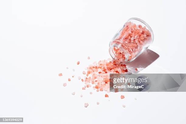 pink himalayan salt spilled from a glass jar - salt cellar stock pictures, royalty-free photos & images