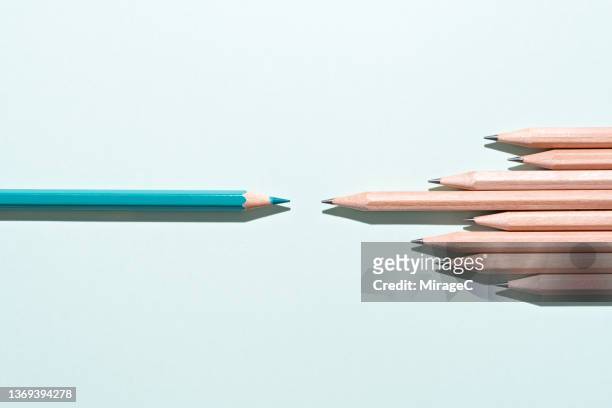green pencil as opposite to other pencils side by side - reversing stock pictures, royalty-free photos & images