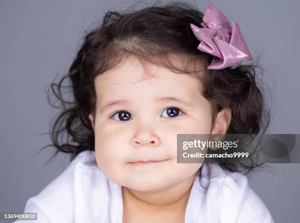 adorabile scatto alla testa di una bambina di un anno, sta guardando direttamente alla telecamera sorridendo - one baby girl only foto e immagini stock