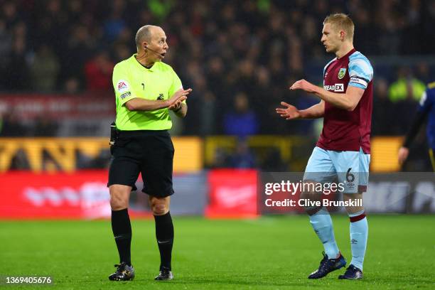 Ben Mee of Burnley and match referee Mike Dean interact during the Premier League match between Burnley and Manchester United at Turf Moor on...