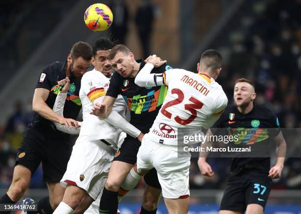 Edin Dzeko of FC Internazionale competes for the ball with Chris Smalling and Gianluca Mancini of AS Roma during the Coppa Italia match between FC...