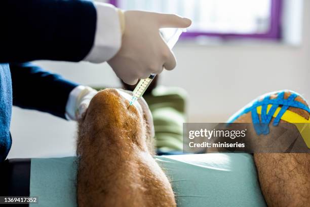 anonymous doctor giving knee injection to the patient - bloody leg stock pictures, royalty-free photos & images