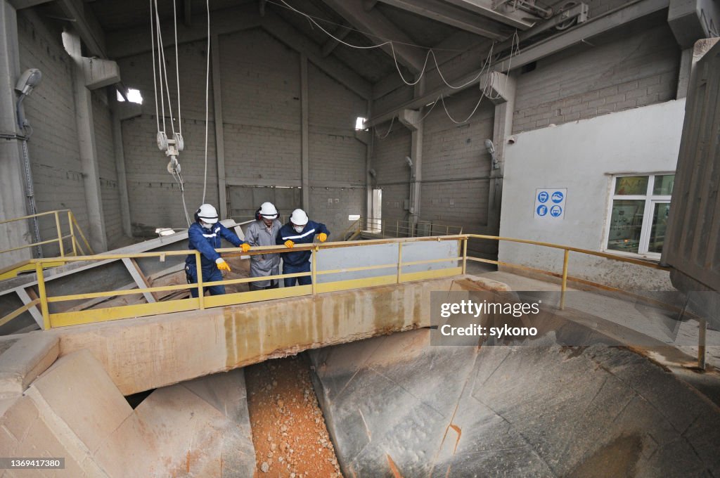 Group of Workers Controlling Sand and Stone Pit