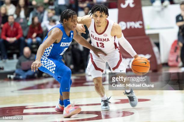 Jahvon Quinerly of the Alabama Crimson Tide looks to maneuver the ball by Sahvir Wheeler of the Kentucky Wildcats at Coleman Coliseum on February 05,...