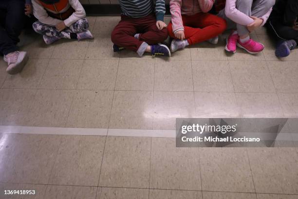 Student sit in a hallway to watch fellow students and after-school volunteers dress in festive lion costumes and dance at Yung Wing School P.S. 124...