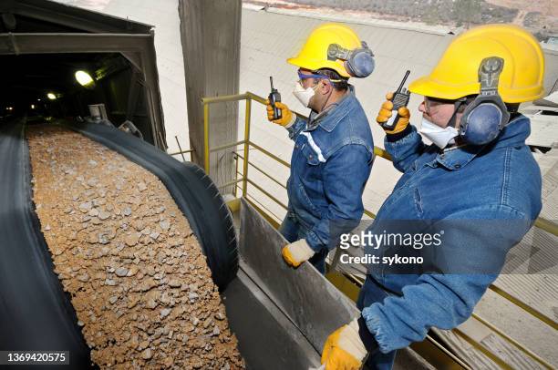 two specialists examining load at sand conveyor line - geology work stock pictures, royalty-free photos & images