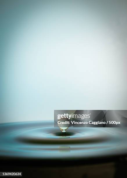 goccia che risorge,close-up of drop splashing in water against white background - acqua splash ストックフォトと画像