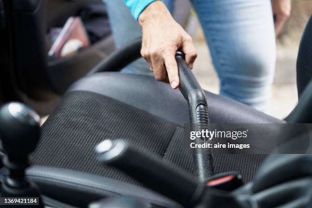 female hand holding the tube of the vacuum cleaner and cleaning the car seat - cleaning inside of car stock pictures, royalty-free photos & images