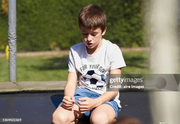 little boy sitting on the floor very worried with his head down - fault sports stock pictures, royalty-free photos & images