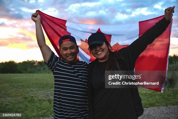 happy asian couple celebrating canada day - canadese cultuur stockfoto's en -beelden