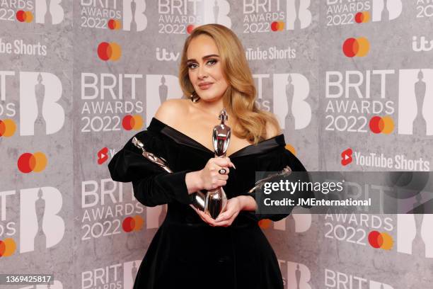 Adele poses with her awards for Song of the Year, Artist of the Year, and Album of the Year in the media room during The BRIT Awards 2022 at The O2...