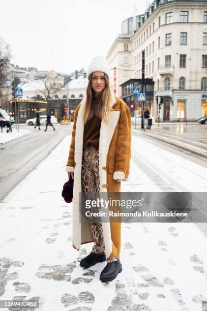 Stephanie Quinn is seen wearing long brown coat, white hat, dark purple bag outside hotel Nobis in Stockholm fashion week Autumn/Winter 2022 on...