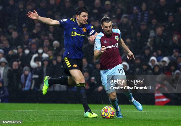 Jay Rodriguez of Burnley moves forward past Harry Maguire of Manchester United to score his team's first goal during the Premier League match between...
