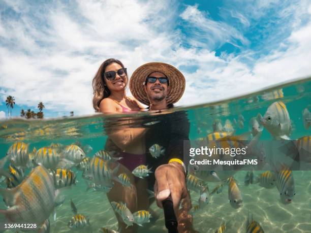 couple taking a selfie with the fish - tropical beach couple stock pictures, royalty-free photos & images