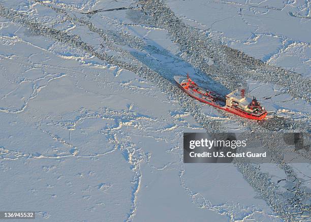 In this photo provided by the U.S. Coast Guard, the Russian tanker Renda powers toward Nome, Alaska with the U.S. Coast Guard Cutter Healy's...