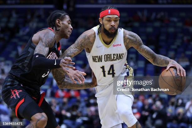 Brandon Ingram of the New Orleans Pelicans drives against Kevin Porter Jr. #3 of the Houston Rockets during the first half at the Smoothie King...