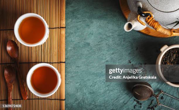 chinese teapot, cups and dry green tea. - hojas de té secas fotografías e imágenes de stock