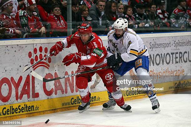 Johan Ejdepalm of EHC Muenchen uses his stick against Jason Jaspers of Koelner Haie during the DEL match between Koelner Haie and EHC Muenchen at...